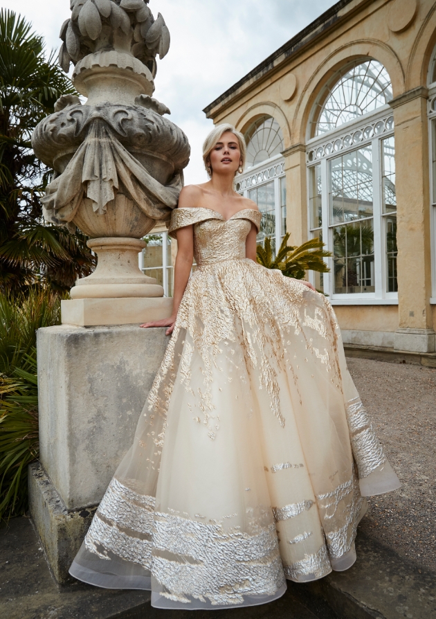 Model on a garden terraced in a gold and silver dress