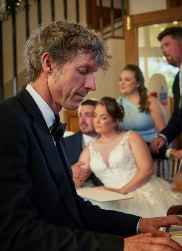 Paul Arnold playing the piano at a wedding 