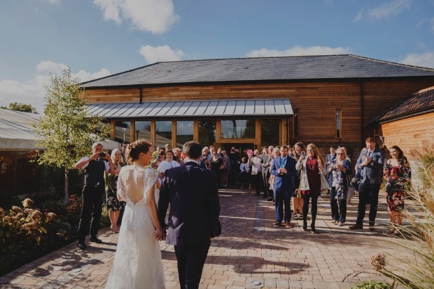front of barn with bride and groom and guests