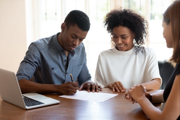 couple signing document at a table