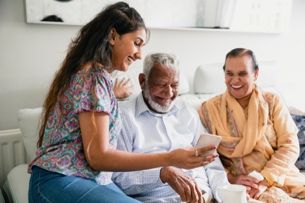 daughter show parents on the sofa something on her phone 