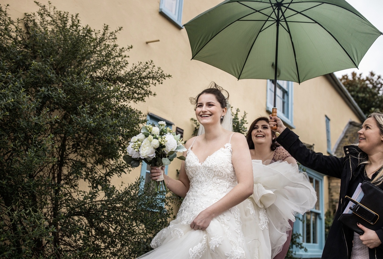 Bride sheltered from rain