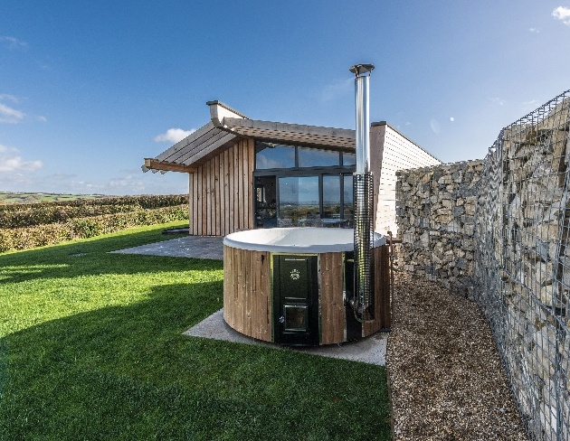 wooden and large window chalet-style property hot tub field views