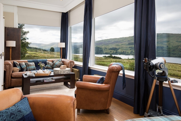 sofas in lounge with view through panaromic windows of lock