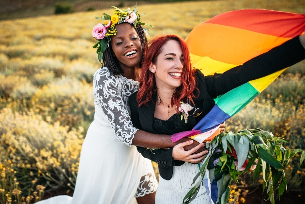 couple joyous in field in wedding outfits