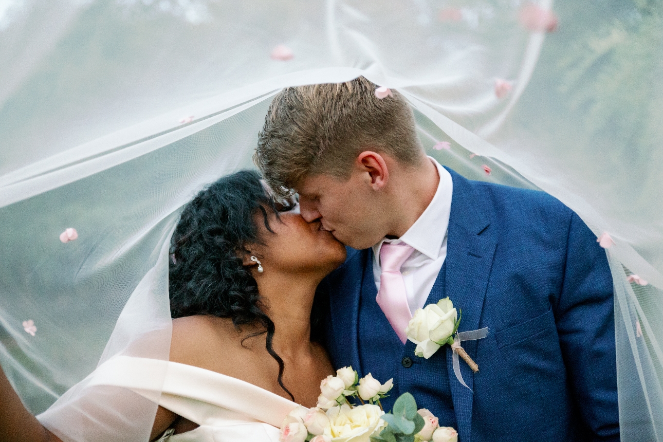 Couple kiss under bride's veil