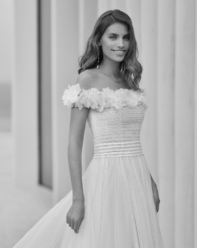 Model wearing dress with off-the-shoulder floral straps