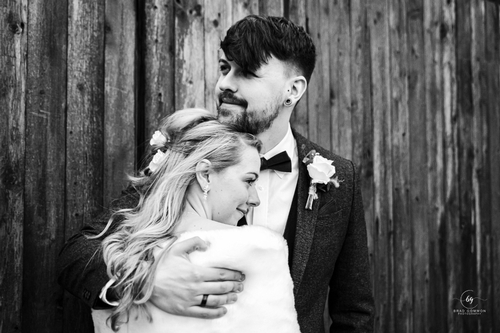 black and white image of bride with her head on groom's chest