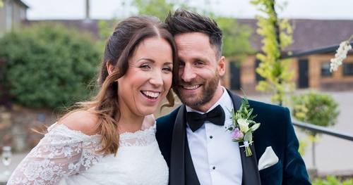 bride and groom laughing together looking at camera