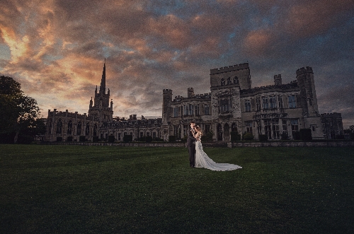 artistic shot at night of couple in front of historic building