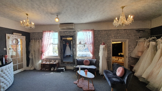 inside the boutique, patterned wallpaper, chandeliers, dresses on rails