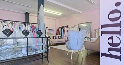 inside a bridal boutique with pink walls and jewellery cabinets 