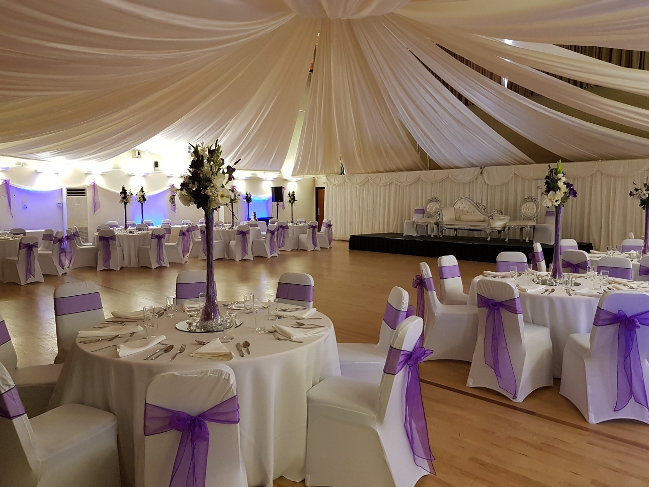 Inside The Rufus Centre with white draping and chairs with white chair covers set up for a ceremony