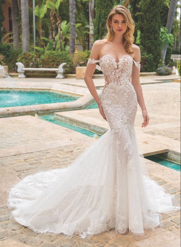 model in a figure hugging fishtail lace gown with off shoulder straps