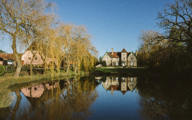 grey stone county house in front of large lake