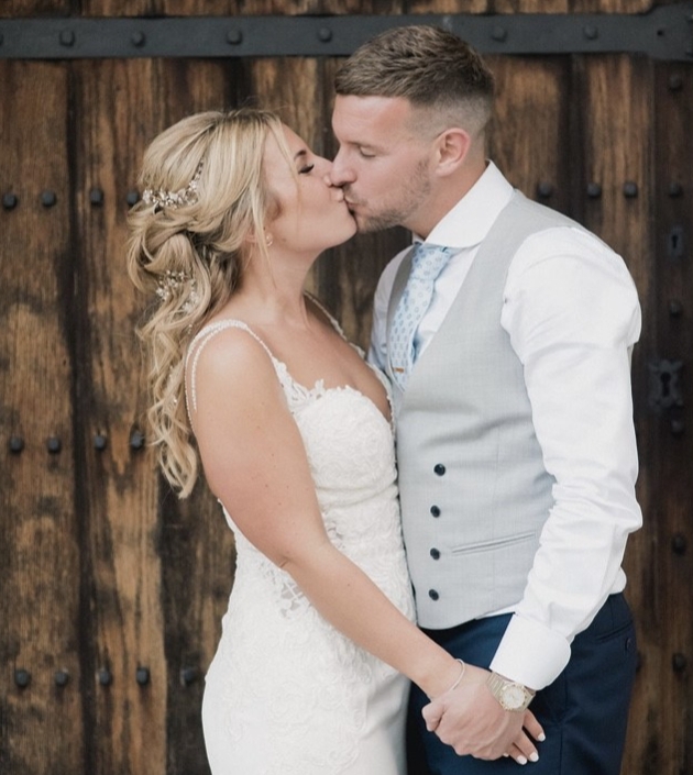couple kissing in front of barn door