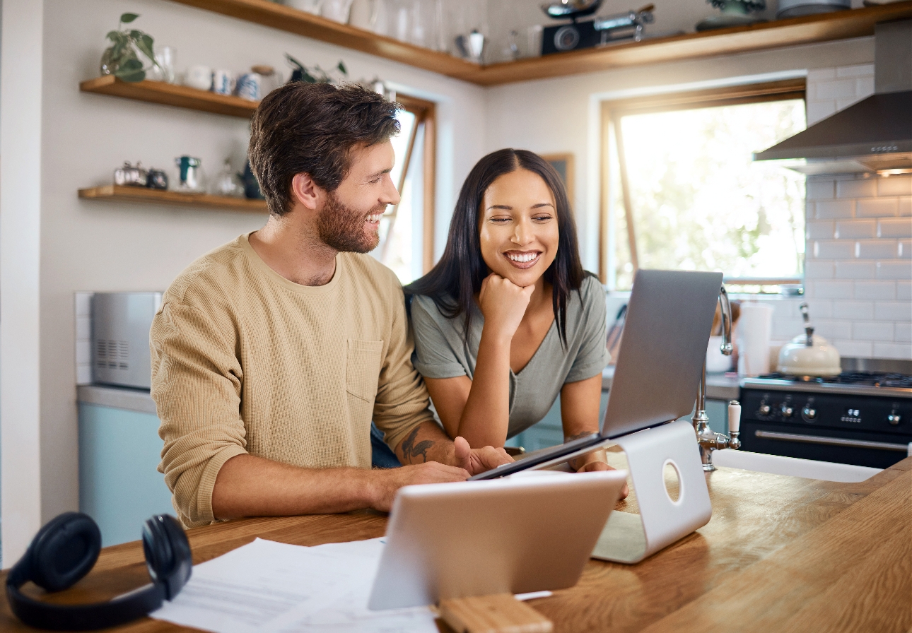 couple at a breakfast bar looking at laptop 