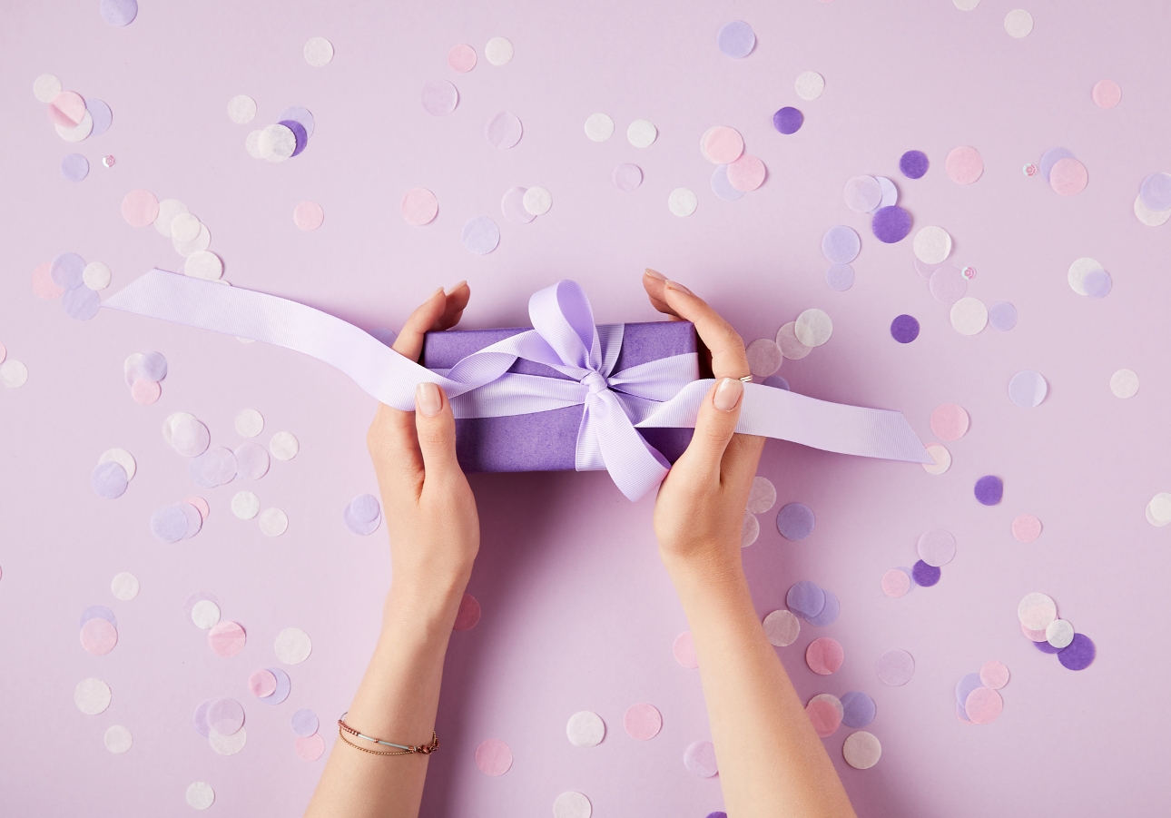 hands holding a purple present