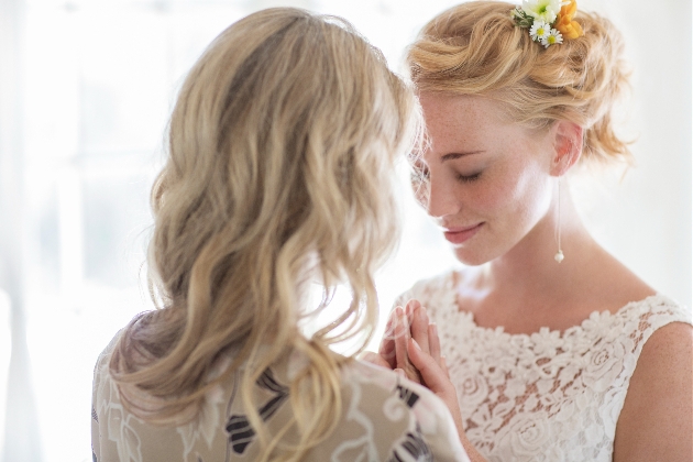 bride and her mum closed eyes holding hands