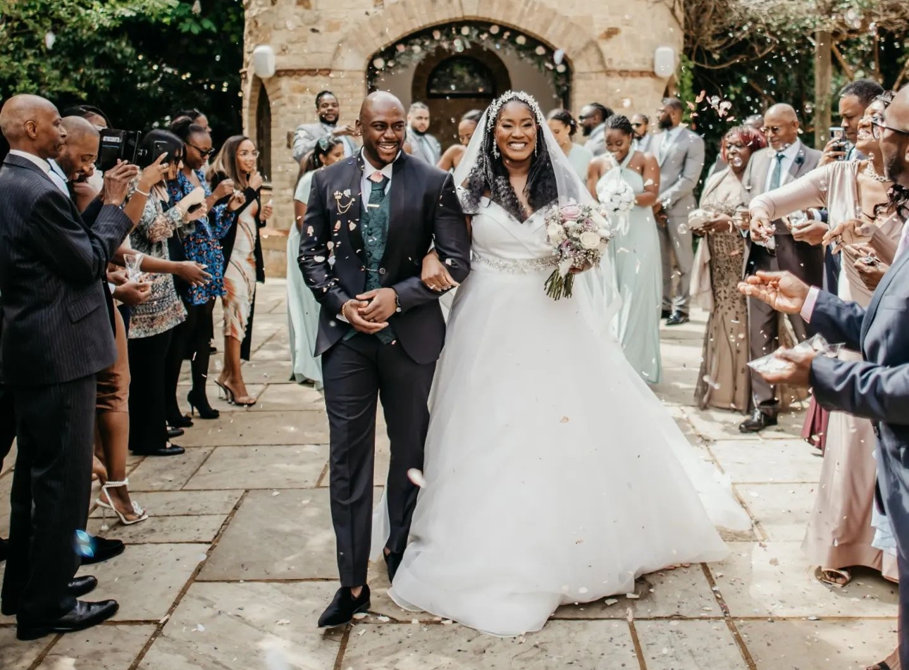 bride and groom outside under confetti arch