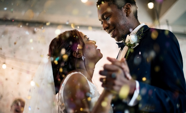 couple dancing at wedding in blue suit and wedding dress