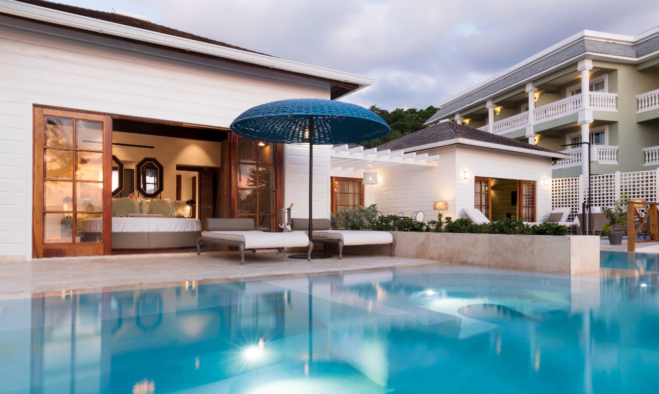 suite in hotel low rising with outdoor pool at night and two loungers with ice bucket in middle