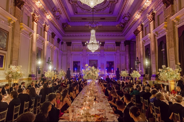 large stately room with banquet tables for a wedding reception ornate ceilings chandeliers
