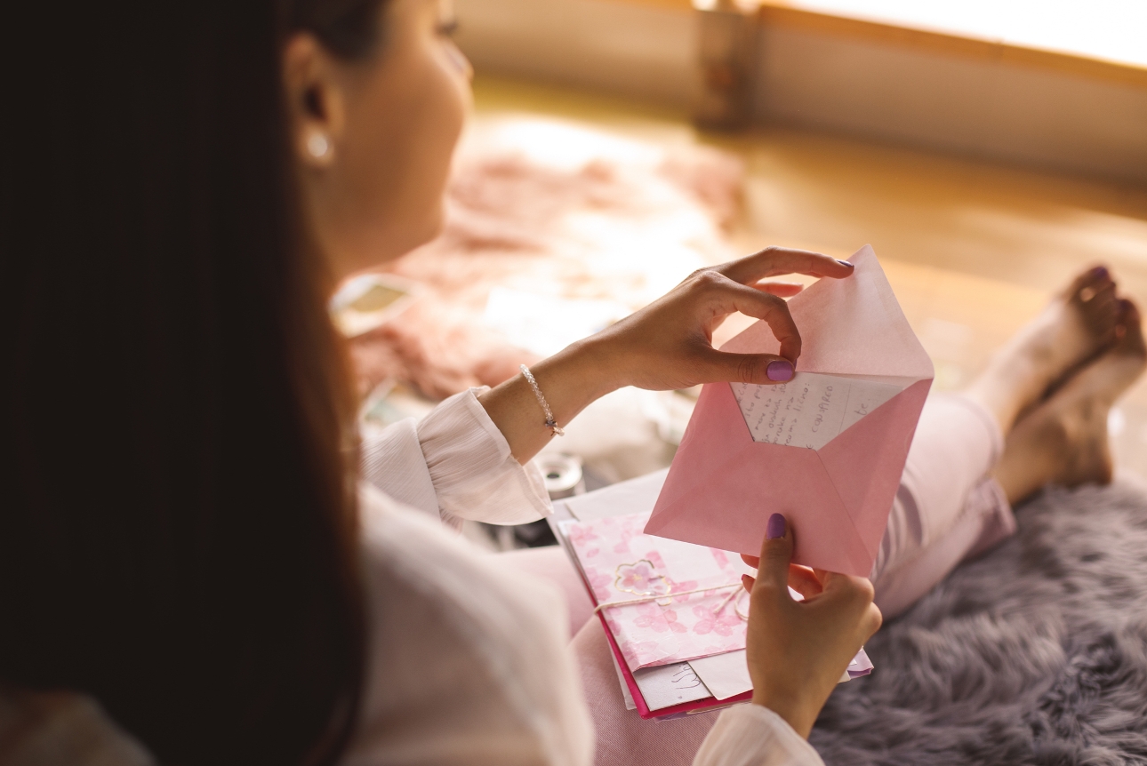 woman reading a letter from an envelope