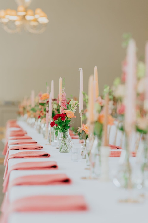 pink candles and flowers on a long table