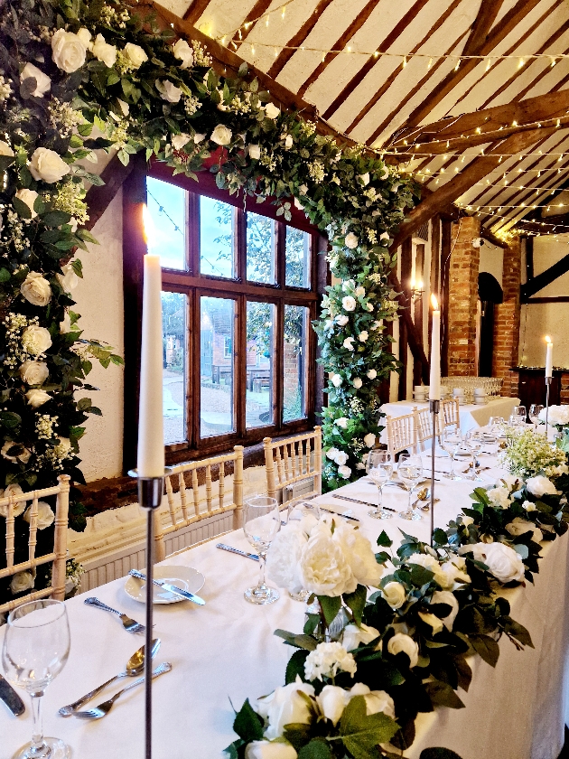 floral moongate behind a top table with flowers on the table