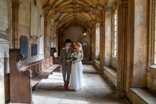 wedding couple walking down a marbled hallway cloisters