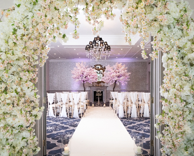 ceremony room with chivari chairs and floral decorations and blossom trees