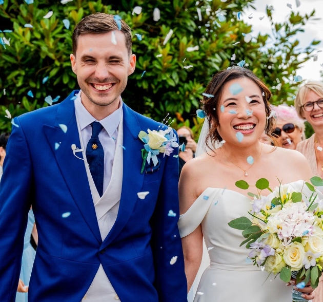 Wedding photographer capturing candid moments during a ceremony with guests in the background